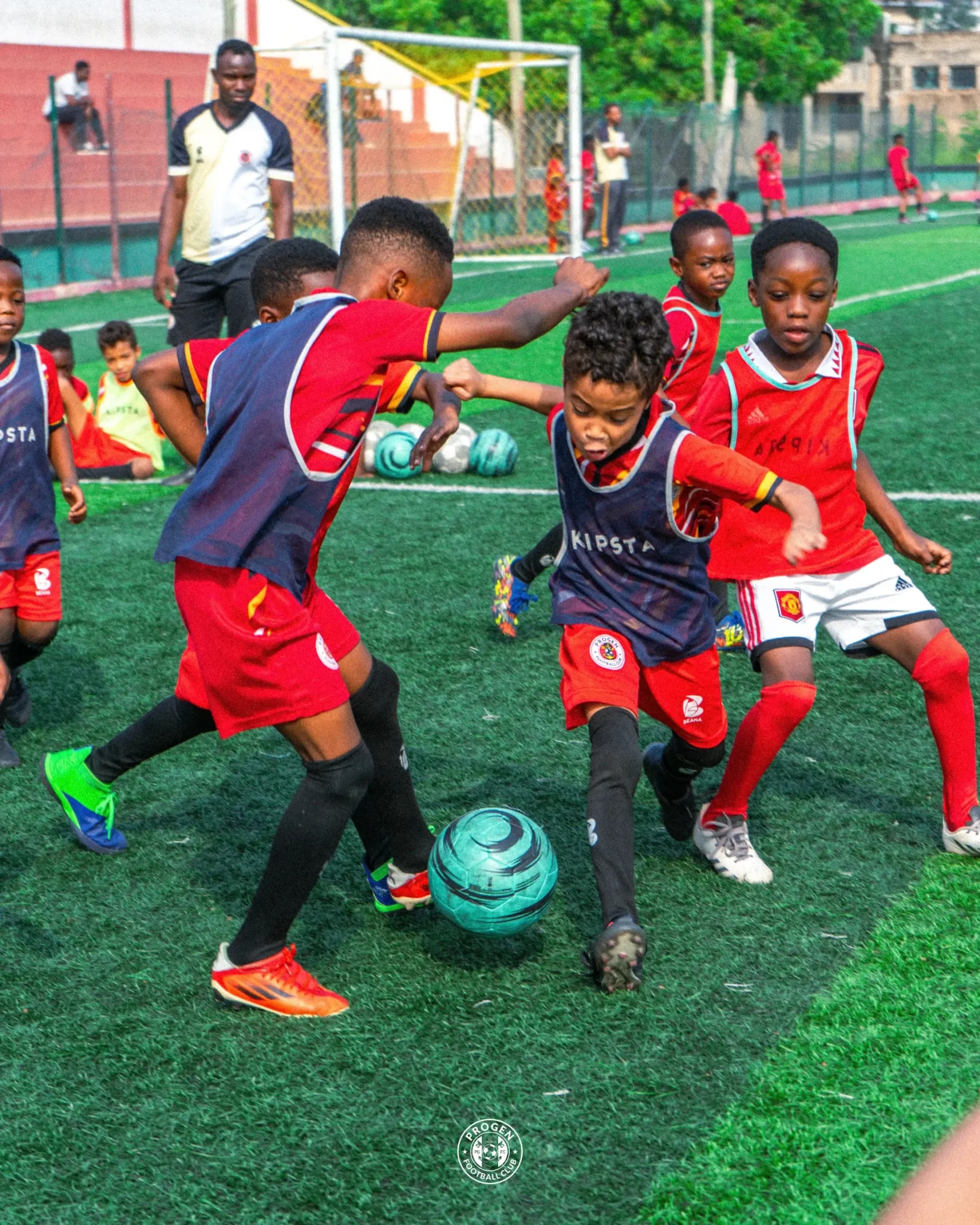 Young ProGen Academy players competing for the ball on an astroturf pitch